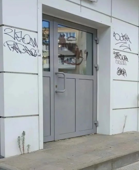 Дверь и стена входной группы с надписями и следами маркера